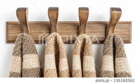 Close-up of Rustic Wall Hooks Displaying Cozy Textured Towels in Neutral Tones 136168562