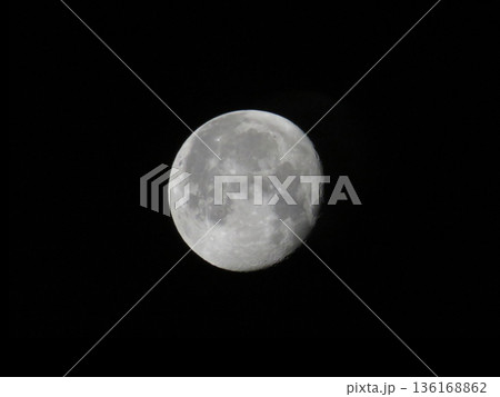 Moon is in the waning phase and is against a dark night sky. Moon is in the waning phase and is against a dark night sky. 136168862