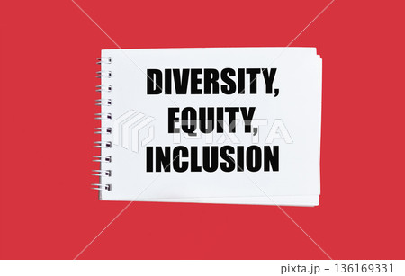 The words Diversity, Equity and Inclusivity in the notebook on a red background. 136169331