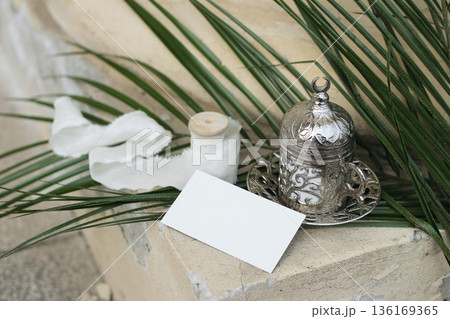Blank White Business Card Mockup. Silver Arabic Turkish Coffee Cup. Palm Leaves. Blurred beige background. Ramadan, Eid Mubarak Still Life. Islamic Invitation, Branding, Wedding Stationery Background 136169365