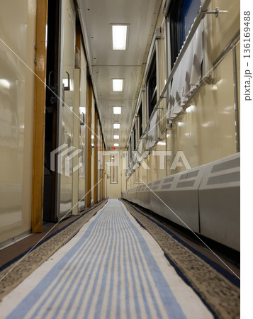 Train journey corridor presenting empty pathway with blue striped runner carpet Train journey corridor presenting empty pathway with blue striped runner carpet 136169488