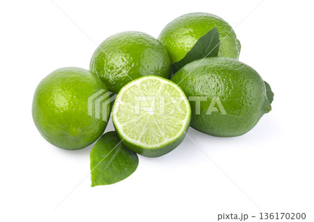 Fresh green limes with leaf and sliced fruit 136170200
