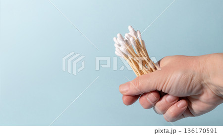 Hand holding eco-friendly bamboo cotton swabs for hygiene 136170591