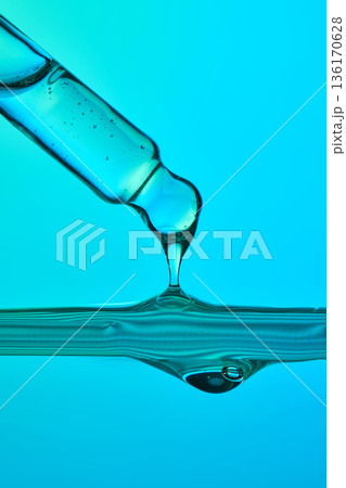 Pipette dripping blue serum fluid in wave Pipette dripping blue serum fluid in wave 136170628