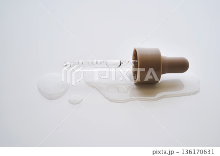 Skincare pipette dropping serum on white background Skincare pipette dropping serum on white background 136170631