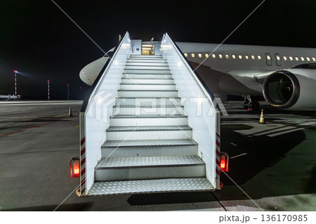 Modern passenger aircraft with stairway at the night airport Modern passenger aircraft with stairway at the night airport 136170985