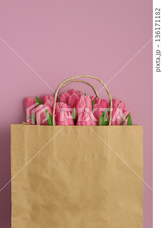 Gift Bag with Pink Tulips on Pink Background. Valentines or Mothers Day Celebration 136171182