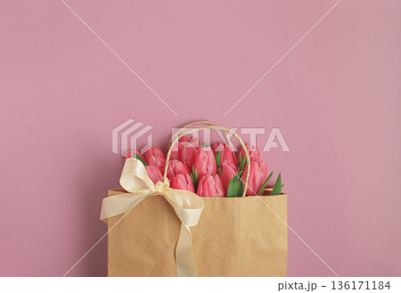 Gift Bag with Pink Tulips on Pink Background. Valentines or Mothers Day Celebration Gift Bag with Pink Tulips on Pink Background. Valentines or Mothers Day Celebration 136171184