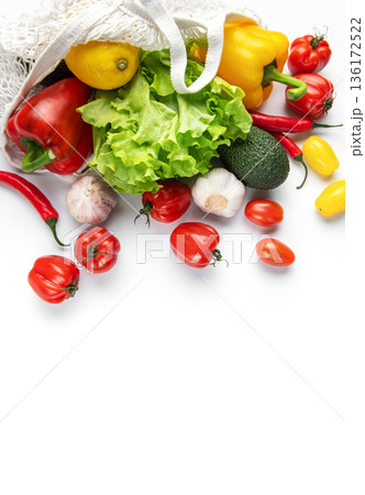 Fresh organic produce spilling from reusable mesh bag 136172522