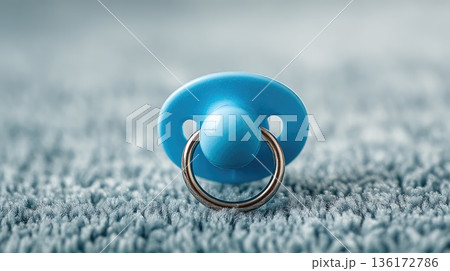 Blue Baby Pacifier Lying on Soft Carpet in Cozy Home Interior Close-Up Blue Baby Pacifier Lying on Soft Carpet in Cozy Home Interior Close-Up 136172786