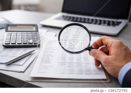 Financial Audit Concept with Magnifying Glass Over Business Documents Financial Audit Concept with Magnifying Glass Over Business Documents 136172791