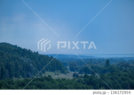 Rainy landscape of countryside forests and valley. Wet summer weather, rainy clouds in the sky, calm nature 136172954