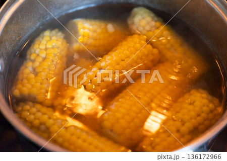 Close up of boiling corn in a pot. Fresh young corn boiling in a pot on stove, fresh tasty corn Close up of boiling corn in a pot. Fresh young corn boiling in a pot on stove, fresh tasty corn 136172966