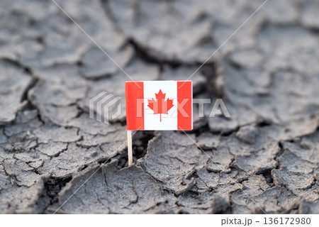 Flag of Canada in cracked dirt. Water problems, hot rainless weather in Canada 136172980