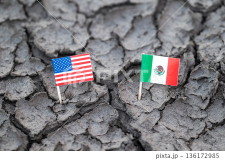 Economic, political problems between US and Mexico concept. Flag of USA and Mexico on textured dry soil, big crack between flags Economic, political problems between US and Mexico concept. Flag of USA and Mexico on textured dry soil, big crack between flags 136172985