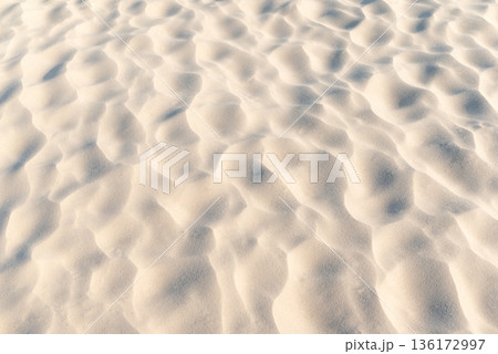 Close up of sand on beach. Clean sand with waves made by wind, beautiful nature texture 136172997