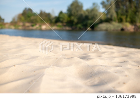Close up of sand beach on river. Sunny day on river sandy beach, place for swimming 136172999