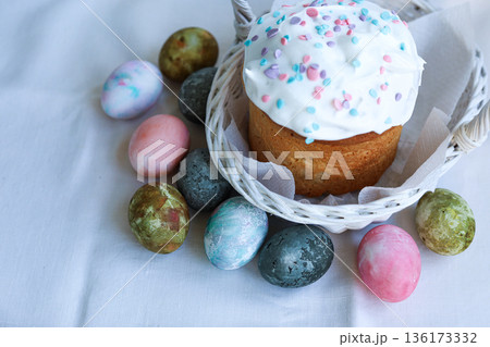 Orthodox Easter kulich in a white basket next to colorful eggs, classic Easter composition Orthodox Easter kulich in a white basket next to colorful eggs, classic Easter composition 136173332