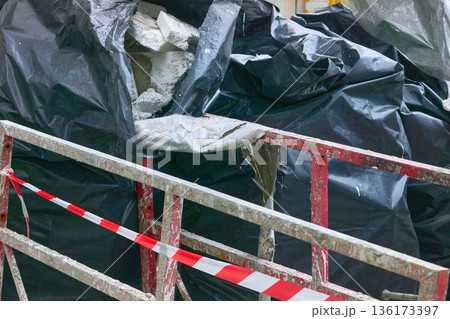 Cleaning.Metal red fencing,polypropylene filled bags with garbage 136173397
