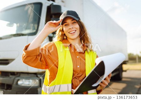 Portrait of woman truck driver in casual clothes standing in front of truck. Transport industry 136173653