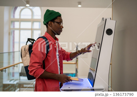 Progressive young man using self-service electronic terminal to pay in store without salesperson Progressive young man using self-service electronic terminal to pay in store without salesperson 136173790