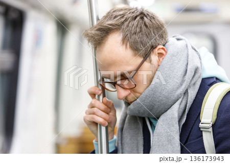 Tired exhausted man standing in subway. Tired exhausted man standing in subway. 136173943