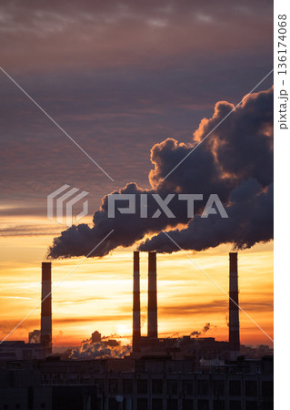 Smoke from factory pipe of heat station in city in winter. Fuel oil or natural gas-fired power plant Smoke from factory pipe of heat station in city in winter. Fuel oil or natural gas-fired power plant 136174068