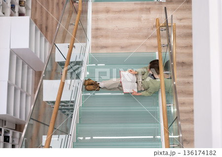 Diligent female student prepares for coursework in philosophy reading books to find information Diligent female student prepares for coursework in philosophy reading books to find information 136174182