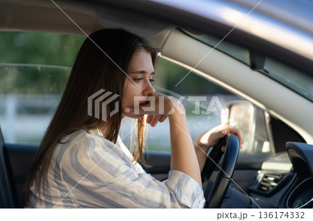 Drunk girl driving car. Unhappy tired young female in vehicle suffering from headache or handover Drunk girl driving car. Unhappy tired young female in vehicle suffering from headache or handover 136174332