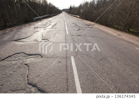 Bad quality road with potholes. Hole in asphalt. Pit, unsafe, hole road. Transportation Bad quality road with potholes. Hole in asphalt. Pit, unsafe, hole road. Transportation 136174345