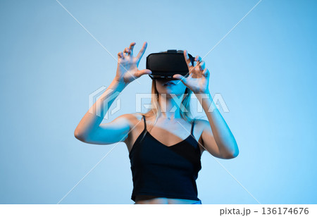 Virtual reality experience with woman using VR headset, interactive technology and metaverse concept 136174676