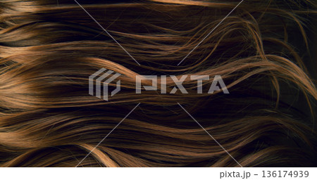 Close-up abstract texture of flowing brown hair forming elegant natural waves and curves. Organic motion, soft light and rich tones create a cinematic beauty background or luxury visual element. Close-up abstract texture of flowing brown hair forming elegant natural waves and curves. Organic motion, soft light and rich tones create a cinematic beauty background or luxury visual element. 136174939