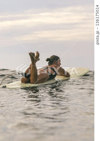 Female Relaxing On Surfboard During Sunset Seeking Peaceful Solitude Female Relaxing On Surfboard During Sunset Seeking Peaceful Solitude 136175014
