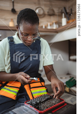 Female technician choosing right tool for fixing kitchen sink Female technician choosing right tool for fixing kitchen sink 136175068