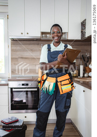 Smiling african american female technician working in kitchen 136175069