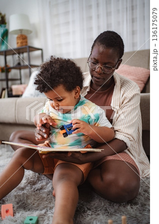 Mother and child reading book and playing at home 136175079