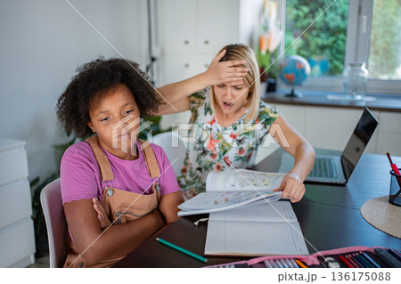 Mom feeling stressed helping bored child with homework Mom feeling stressed helping bored child with homework 136175088