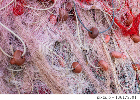 Close up of tangled colorful fishing nets and floats creating textured maritime industry background. Close up of tangled colorful fishing nets and floats creating textured maritime industry background. 136175301