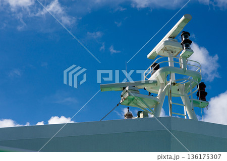 Navigation radar and communication antennas on ship bridge against clear blue sky background. 136175307