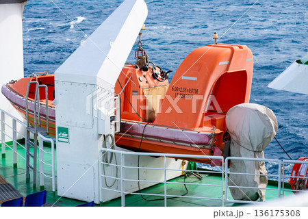 Orange lifeboat secured on ship deck representing safety equipment and marine transport operations. 136175308