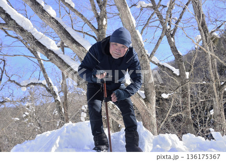 雪道で杖を使ってリハビリをしている老人 雪道で杖を使ってリハビリをしている老人 136175367