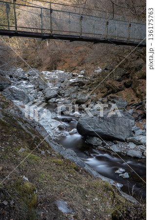 冬の秩父・荒川源流、凍てつく渓谷を流れる清流と登山道の吊り橋 136175763