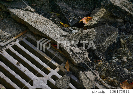 Storm drain grate before removal during road repairs Storm drain grate before removal during road repairs 136175911