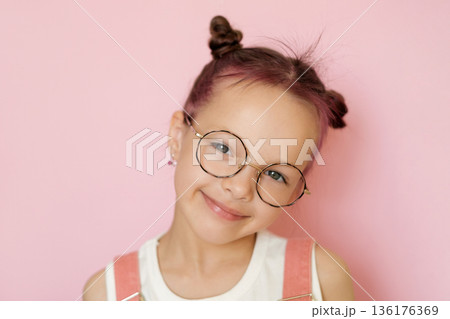 Portrait of a child wearing eyeglasses symbolizing vision care, eye health and eyesight correction. Concept of ophthalmology, children vision protection and medical prevention. 136176369