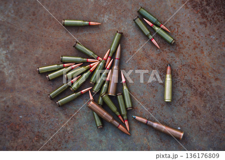 Scattered rifle ammunition cartridges on rusty metal surface 136176809