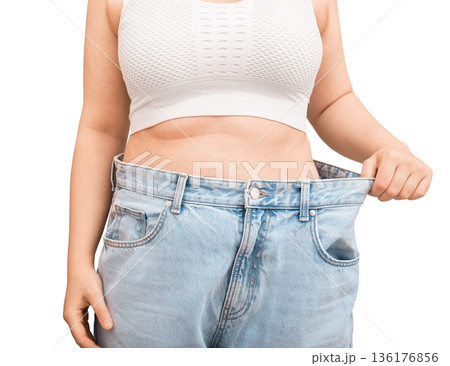 Cropped view of woman showing weight loss result in old jeans. Slim female pulling oversized pants at waist isolated on white background. Diet success concept. High quality photo Cropped view of woman showing weight loss result in old jeans. Slim female pulling oversized pants at waist isolated on white background. Diet success concept. High quality photo 136176856