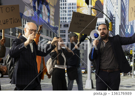 Protesters gather in rally against corrupted government and scandalous politics, holding cardboard posters and banners with angry warning messages focused on democracy and anti-corruption. 136176989