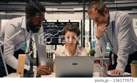 Business collaboration scene, diverse professionals, working together on laptop, data analysis, KPI metrics, modern corporate workspace. Risk assessment, corporate lifestyle, goals. 136177073
