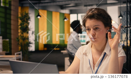 Professional woman concentrating and pondering vision in modern office, considering ideas and strategy while reviewing forecasting reports and insights. Reflection and decision making. Professional woman concentrating and pondering vision in modern office, considering ideas and strategy while reviewing forecasting reports and insights. Reflection and decision making. 136177078