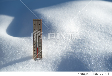 Thermometer in snow showing freezing winter temperature 136177201